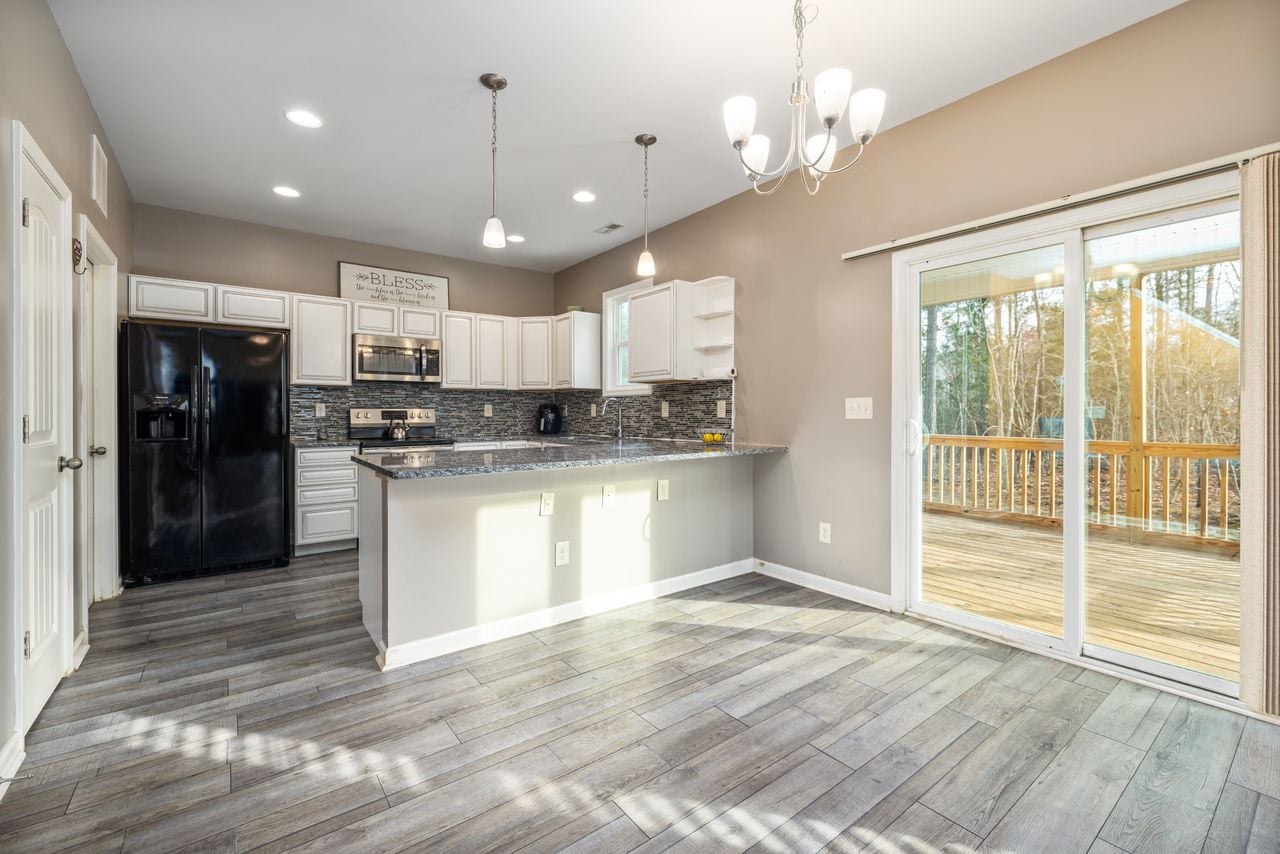 Services Spacious modern kitchen with island and sliding doors to a balcony, ideal for culinary enthusiasts.