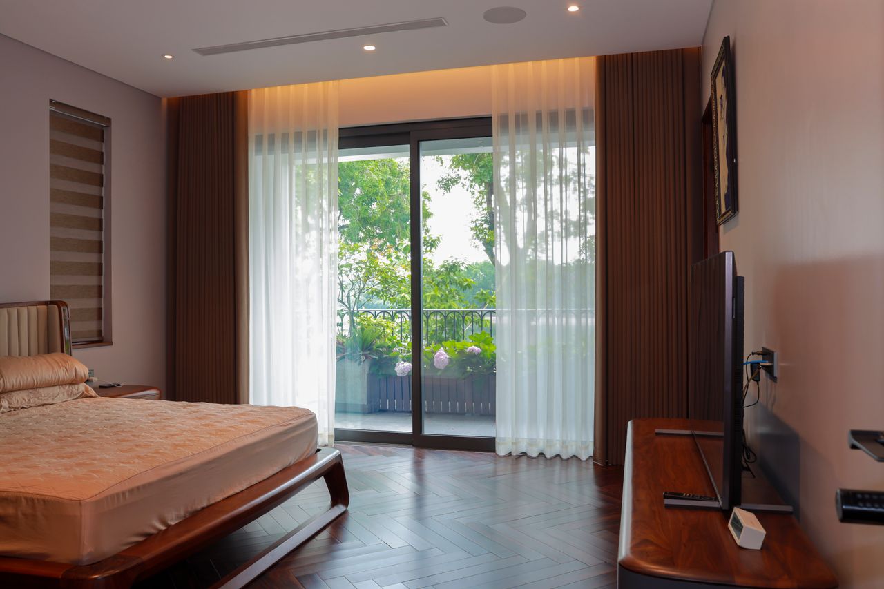 Services Interior of a peaceful bedroom featuring a bed and balcony views of lush greenery.