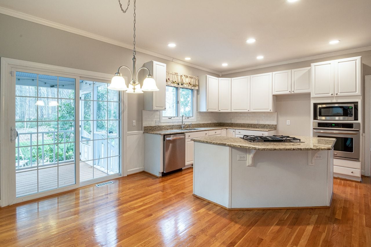 Portfolio Bright modern kitchen featuring marble island and wooden flooring, ideal for family spaces.
