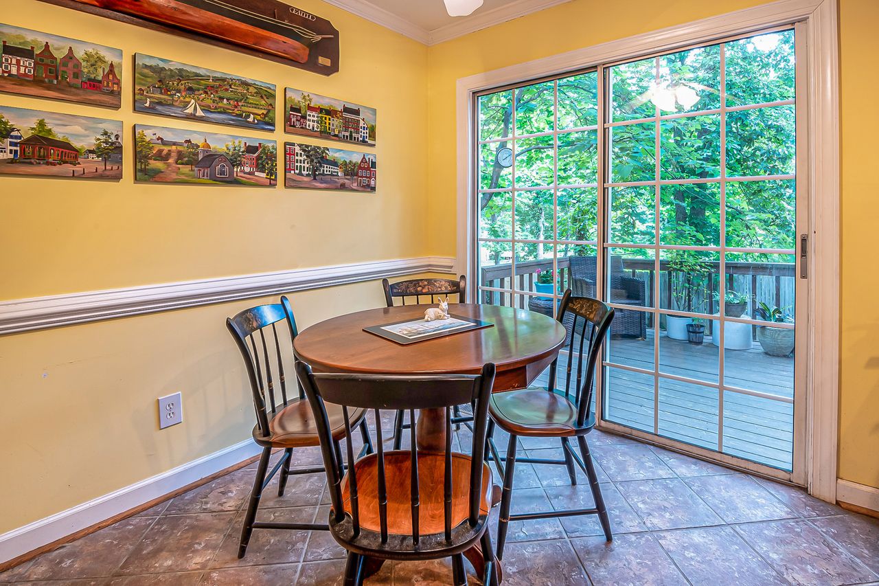 Charming dining area with paintings, table, and sliding door opening to a balcony.